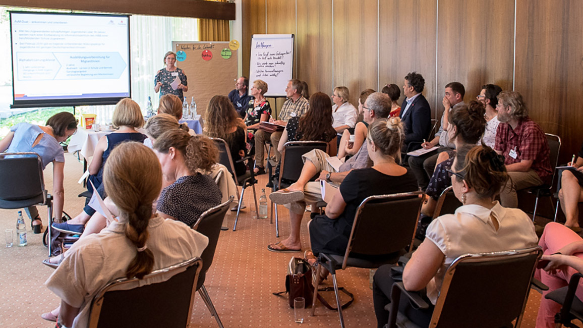 Workshop-Teilnehmende hören einer Referentin zu Workshop-Teilnehmende hören einer Referentin zu